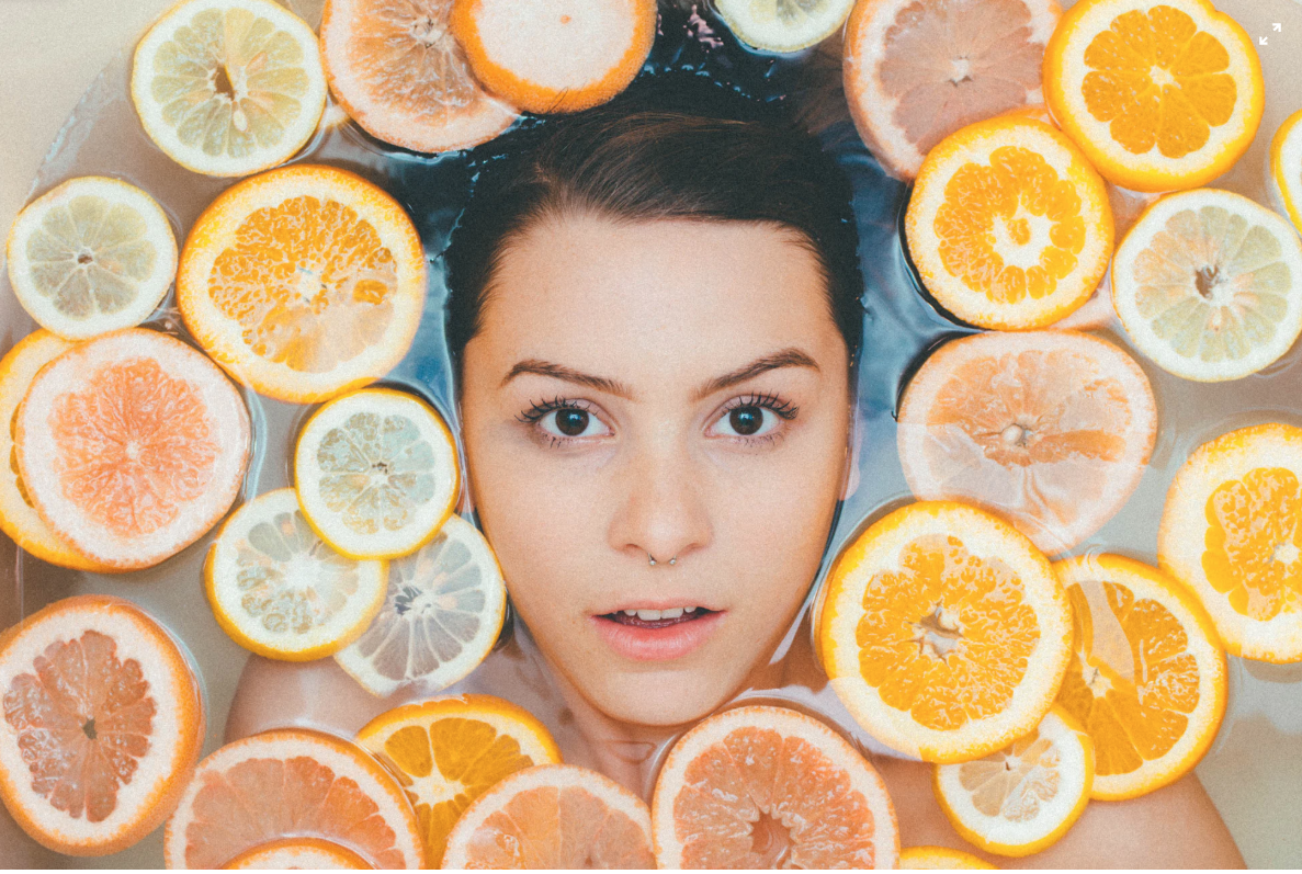 woman submerged in water with oranges